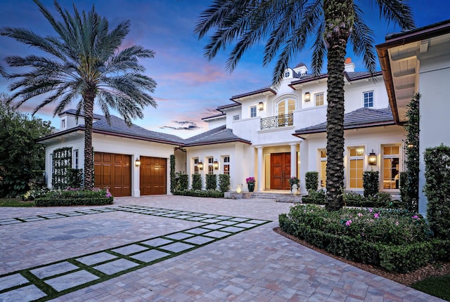 mediterranean / spanish house featuring a balcony and a garage