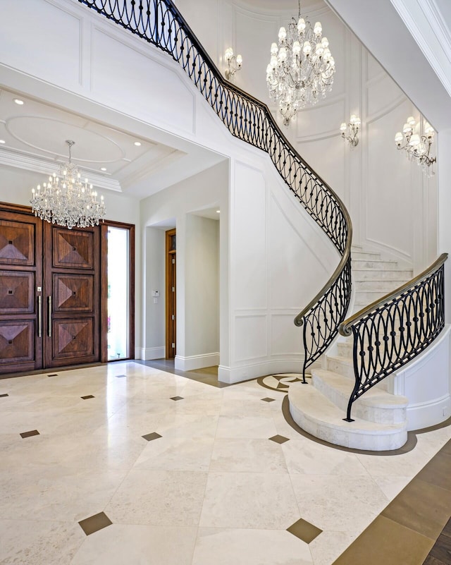 foyer entrance featuring ornamental molding, a notable chandelier, and light tile flooring