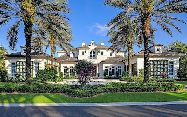 mediterranean / spanish-style house with a front yard and french doors