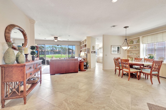 tiled dining room featuring a textured ceiling and built in shelves