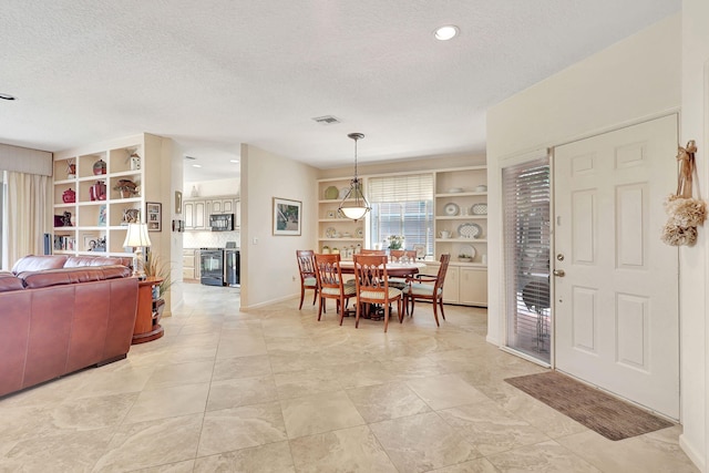 living room with a textured ceiling, ceiling fan, and light tile floors