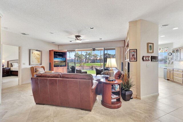 living room featuring built in features, ceiling fan, and light tile floors