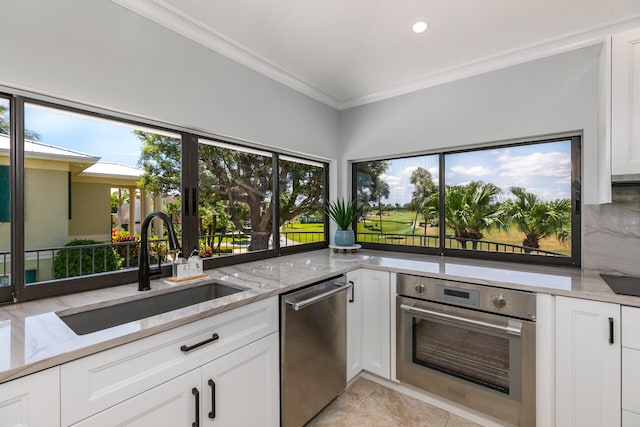 kitchen featuring sink, white cabinetry, stainless steel appliances, and light stone countertops