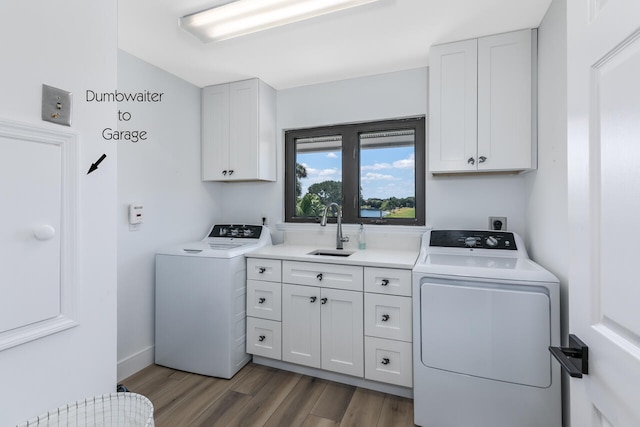 clothes washing area featuring hookup for an electric dryer, hardwood / wood-style floors, independent washer and dryer, sink, and cabinets