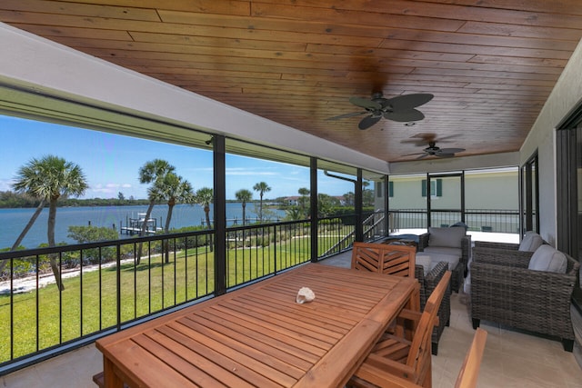 sunroom featuring a water view, wood ceiling, and ceiling fan