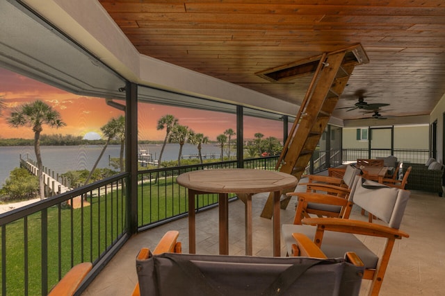 sunroom with wooden ceiling, ceiling fan, and a water view