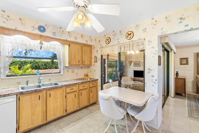 kitchen with light tile patterned floors, ceiling fan, a sink, dishwasher, and wallpapered walls