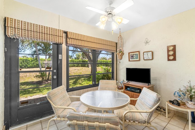 sunroom / solarium featuring a ceiling fan