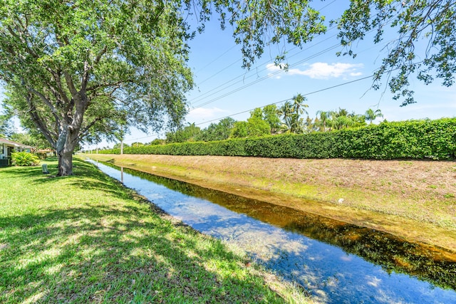 view of home's community with a lawn and a water view