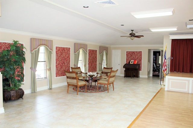 dining space featuring baseboards, a ceiling fan, visible vents, and crown molding