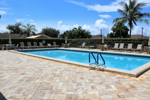 pool with fence and a patio