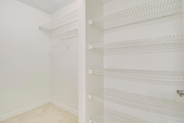 spacious closet featuring light tile flooring