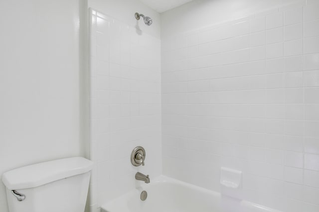 bathroom featuring tiled shower / bath and toilet