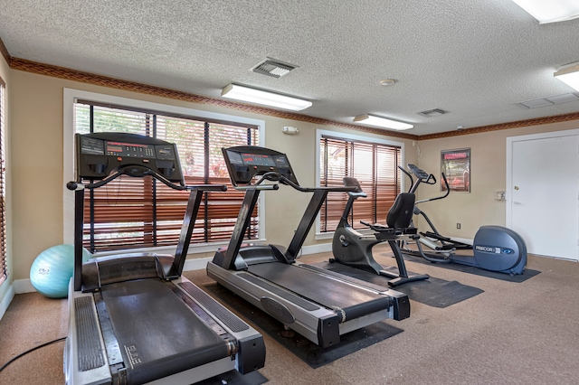 workout area featuring carpet flooring and a textured ceiling