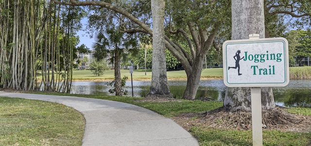 community sign featuring a yard and a water view