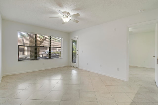 spare room with ceiling fan, a textured ceiling, and light tile flooring