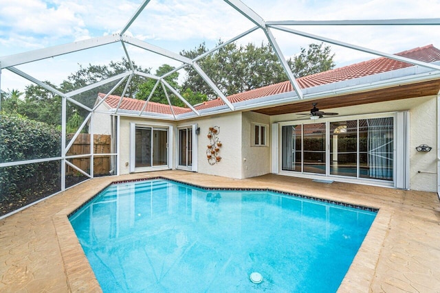 view of swimming pool with ceiling fan and a lanai