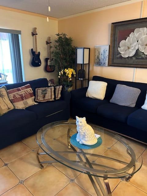 living room featuring ornamental molding and light tile floors