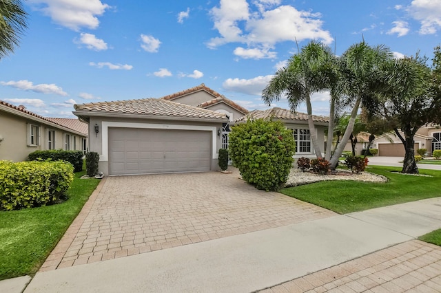 mediterranean / spanish-style house with a garage and a front lawn