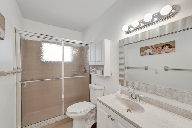 bathroom featuring an enclosed shower, vanity, and toilet