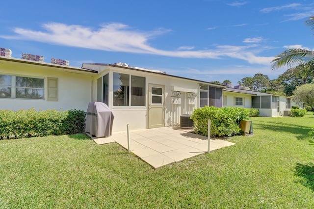 rear view of property featuring central AC, a yard, and a patio area