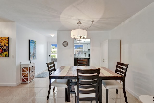 dining room featuring a notable chandelier and light tile floors