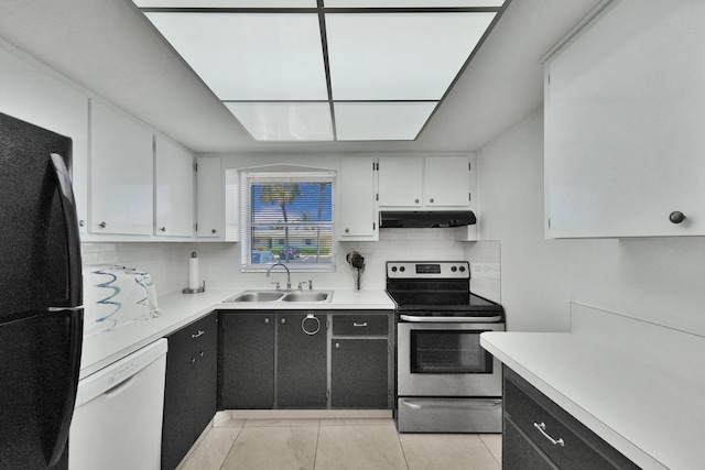 kitchen with backsplash, sink, black fridge, and stainless steel electric range oven