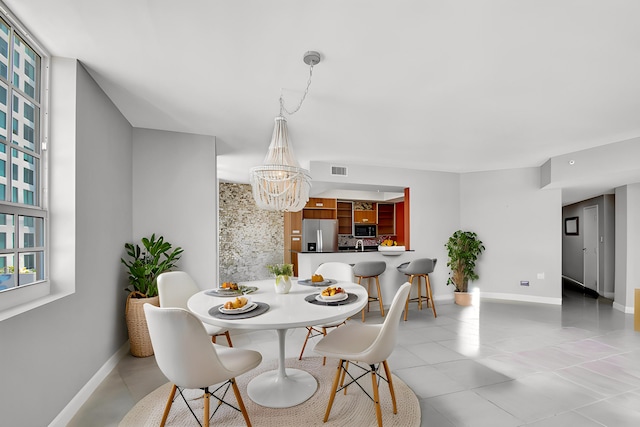 tiled dining area with a chandelier