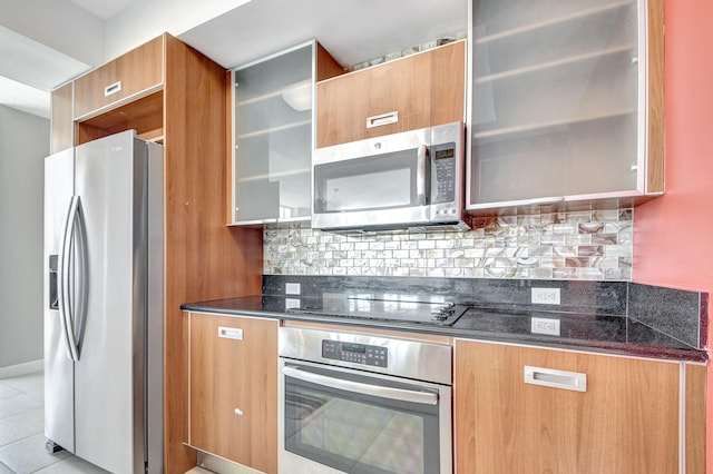 kitchen featuring decorative backsplash, light tile patterned flooring, and stainless steel appliances