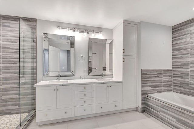 bathroom featuring tile patterned flooring, vanity, tile walls, and shower with separate bathtub