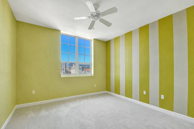 carpeted empty room with ceiling fan and a textured ceiling