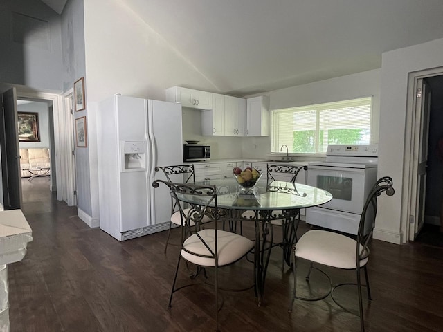 dining room with vaulted ceiling, sink, and dark wood-type flooring