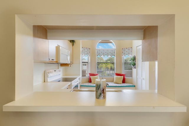 kitchen featuring light brown cabinets, white appliances, and sink