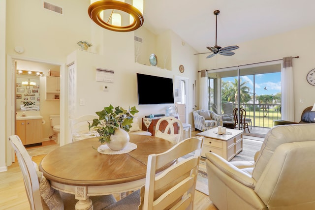 living room featuring high vaulted ceiling, light hardwood / wood-style floors, and ceiling fan