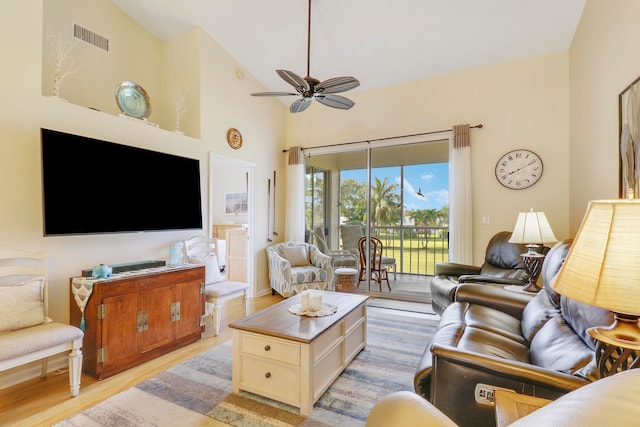 living room with light hardwood / wood-style flooring, high vaulted ceiling, and ceiling fan