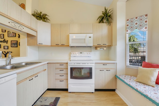 kitchen featuring light brown cabinetry, sink, white appliances, lofted ceiling, and light hardwood / wood-style flooring