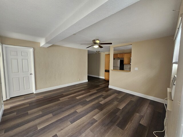 unfurnished room featuring a textured ceiling, beam ceiling, ceiling fan, and dark hardwood / wood-style flooring