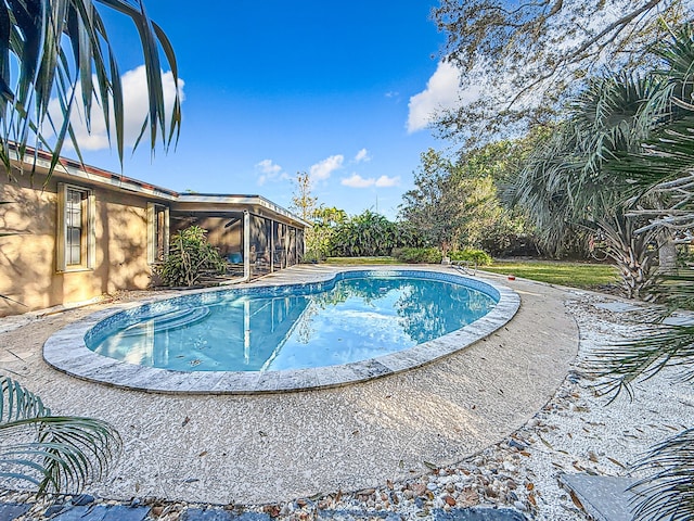 view of swimming pool with a sunroom