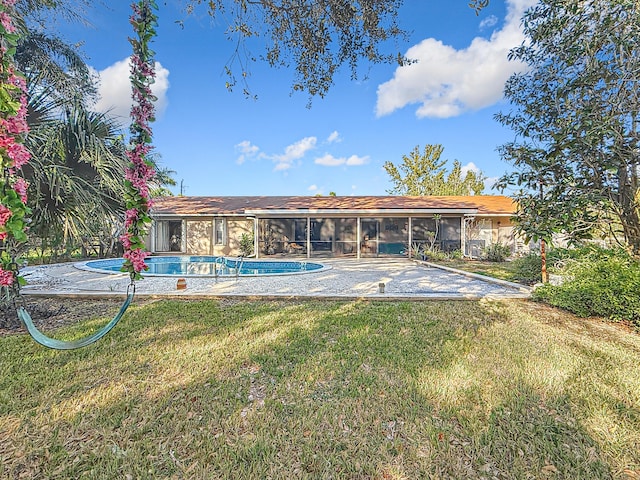 view of swimming pool featuring a yard and a sunroom