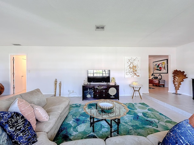 living room with tile patterned flooring and a textured ceiling