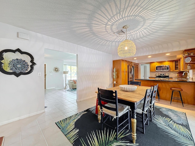 dining room featuring sink and light tile patterned flooring