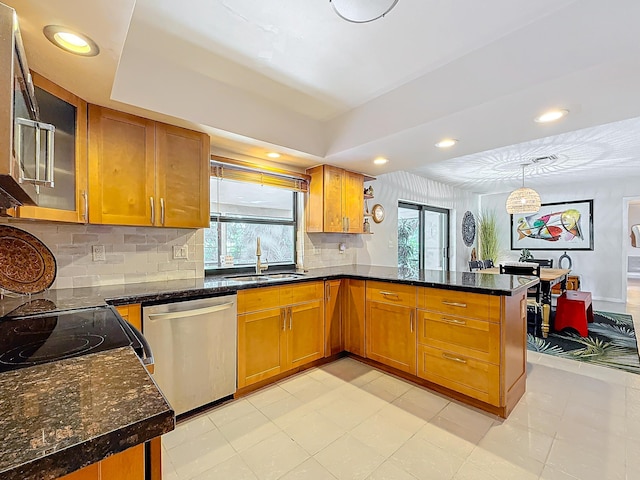 kitchen featuring sink, stainless steel appliances, tasteful backsplash, kitchen peninsula, and decorative light fixtures