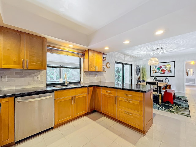 kitchen featuring pendant lighting, sink, stainless steel dishwasher, decorative backsplash, and kitchen peninsula