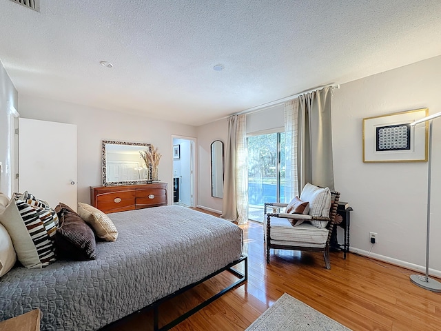 bedroom with wood-type flooring and a textured ceiling