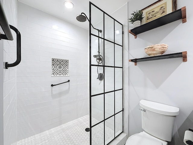 bathroom featuring tiled shower and toilet