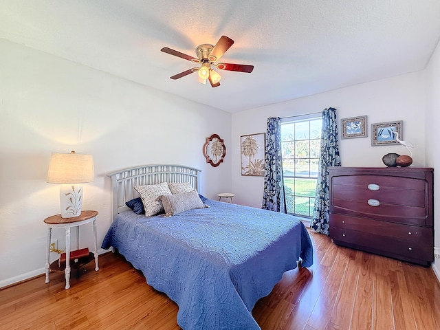 bedroom featuring ceiling fan, a textured ceiling, and light wood-type flooring