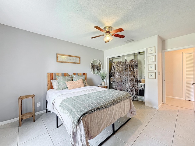 bedroom with light tile patterned floors, a textured ceiling, a closet, and ceiling fan