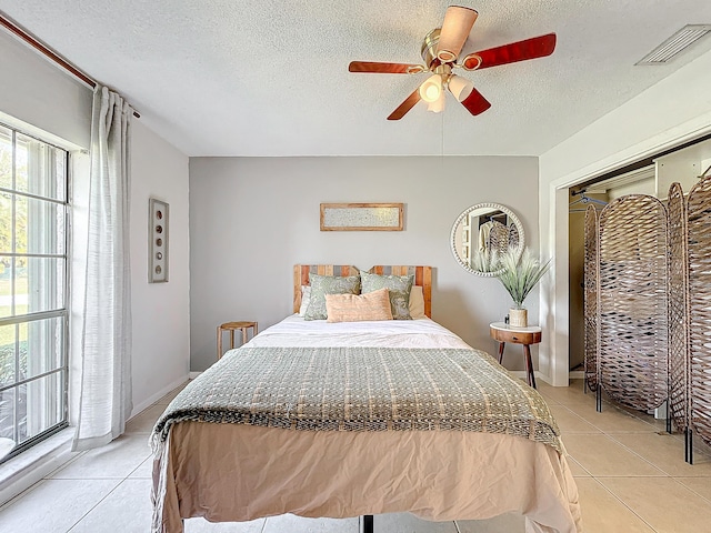 bedroom with multiple windows, ceiling fan, and light tile patterned flooring