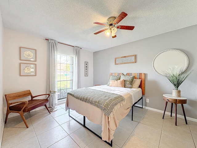 tiled bedroom with ceiling fan and a textured ceiling