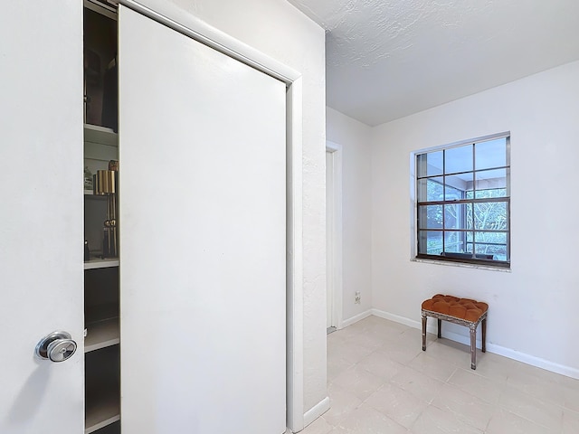 corridor featuring a textured ceiling